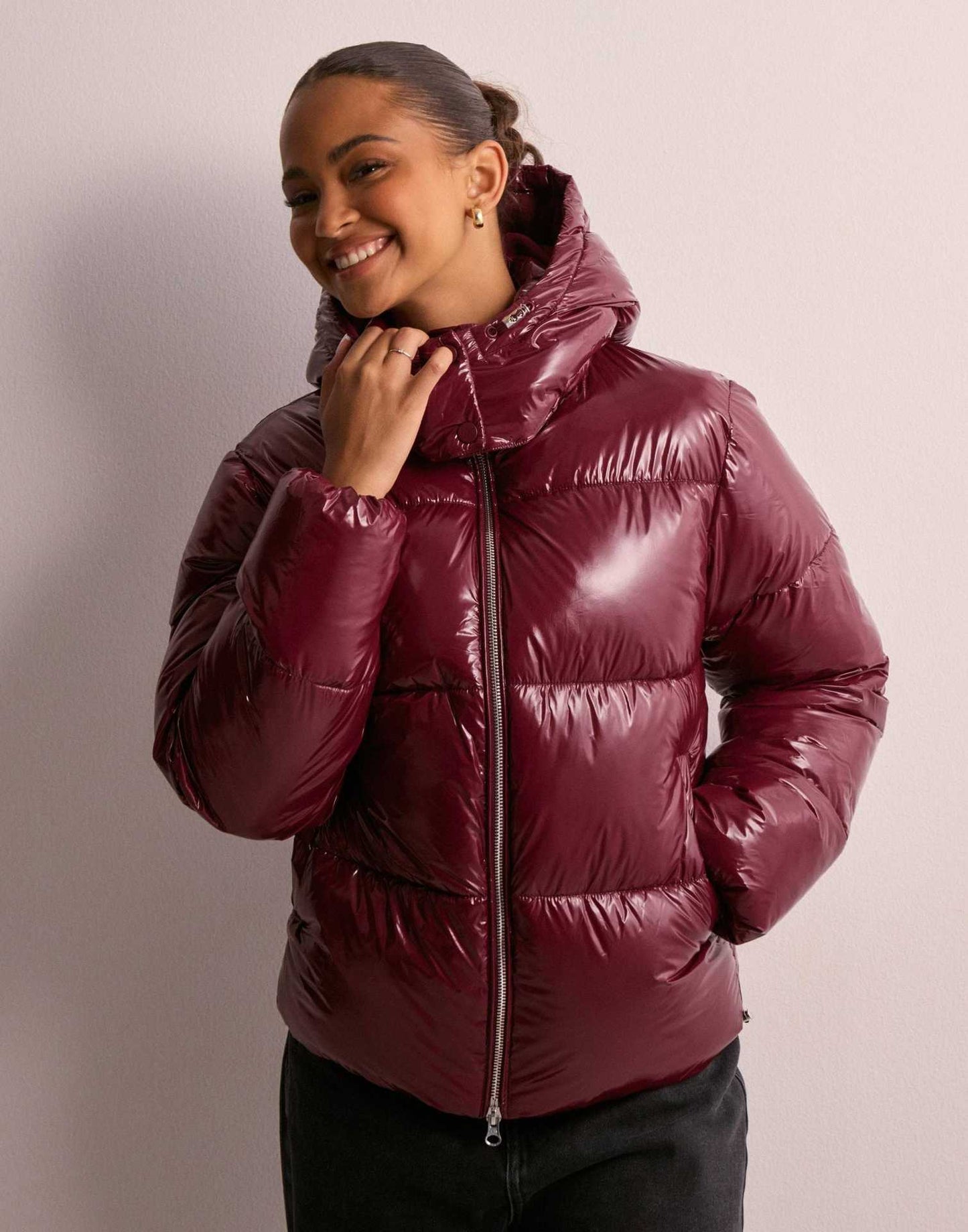 outfit mit bordeaux glänzender pufferjacke und schwarzer jeans