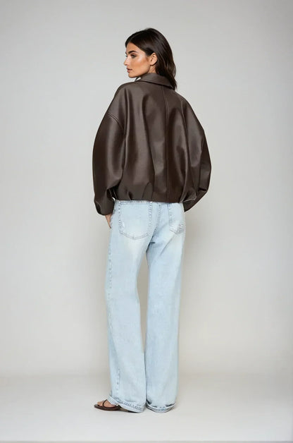 model trägt schwarze oversized vegan-leder jacke mit gürtel und zip