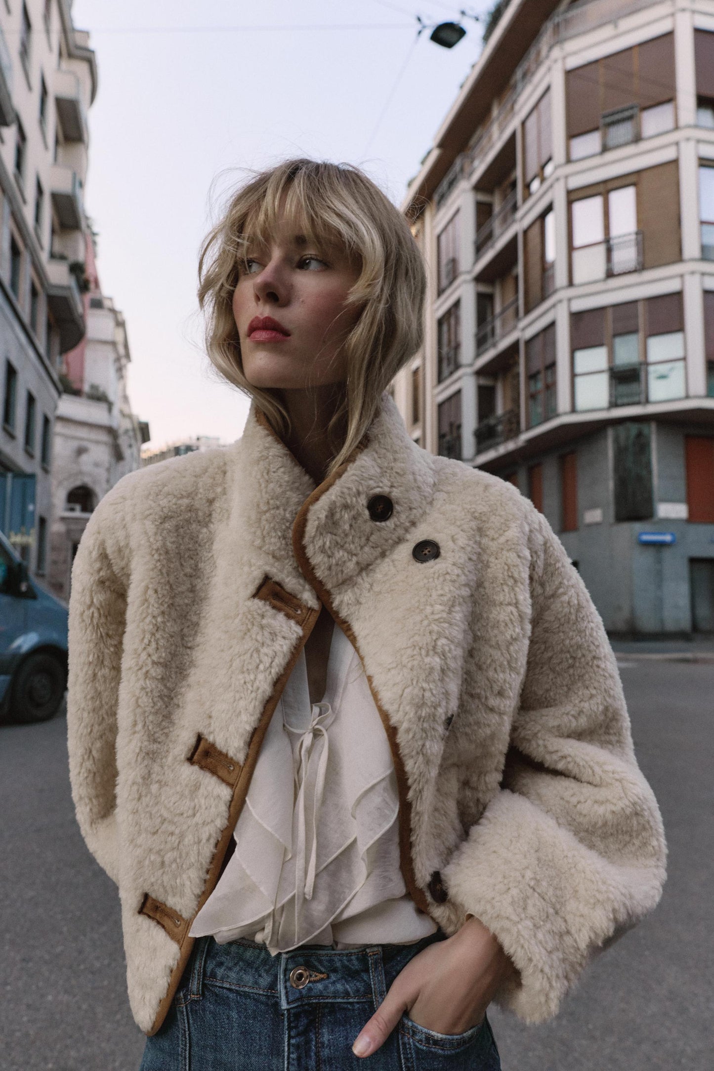 frau trägt beige teddyjacke mit knöpfen auf der straße