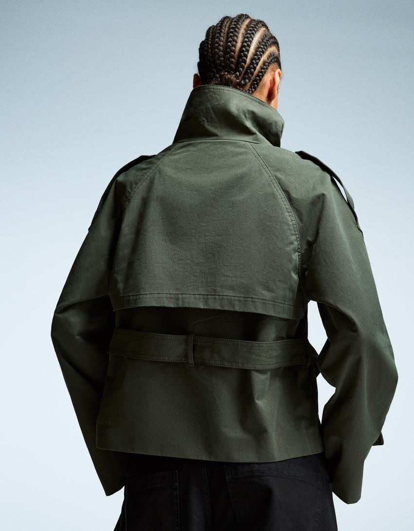 grun kurzer trenchcoat mit bindegürtel flach fotografiert