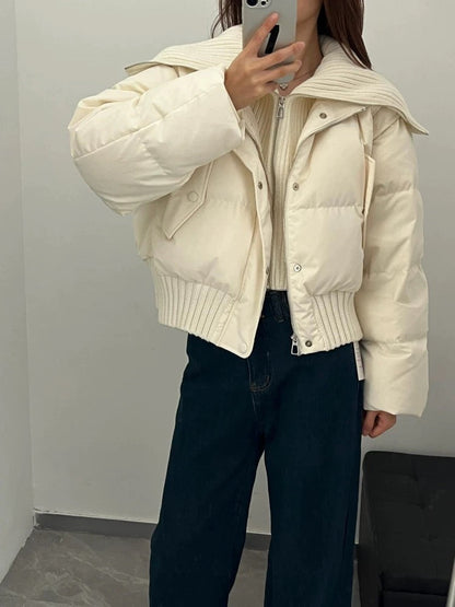 Frau in beiger Pufferjacke mit hohem Kragen und Reißverschluss