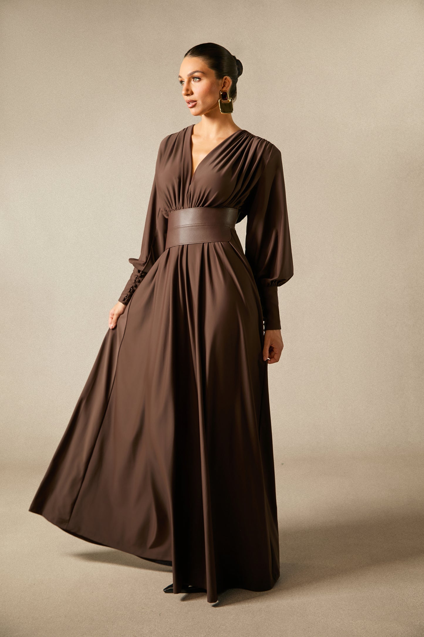 Modell in langem braunen Kleid mit Taillenband