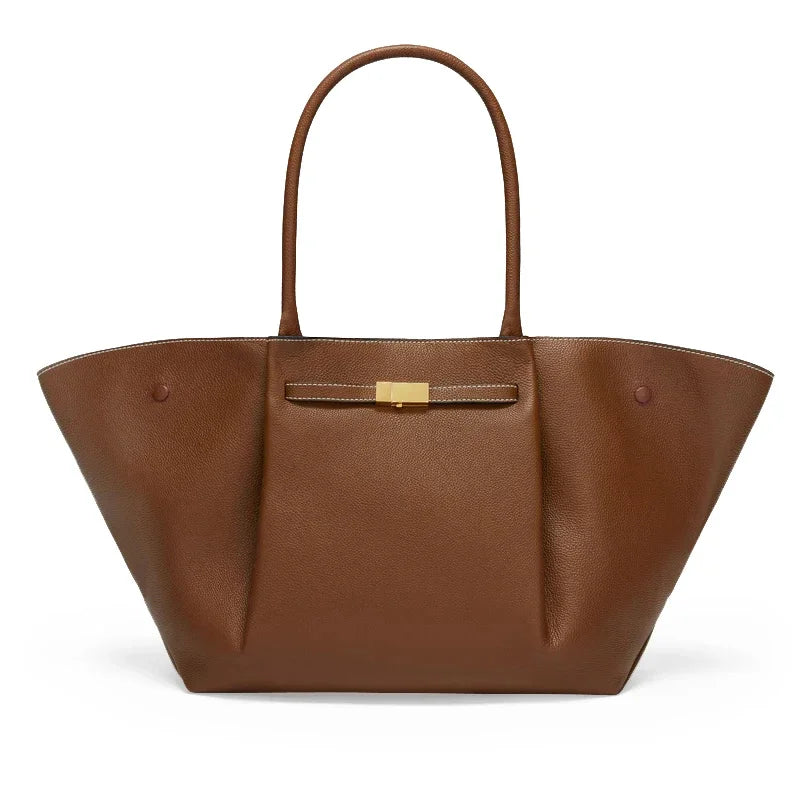 Braune Tote Bag mit goldener Schließe auf hellem Hintergrund